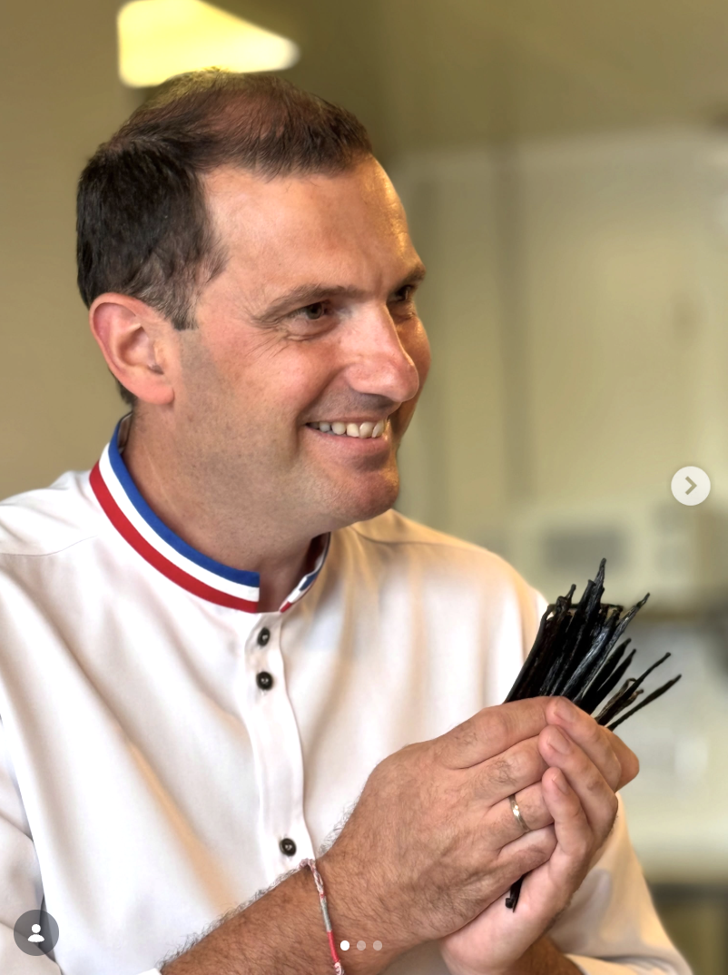 Chef en tenue de cuisine tenant des gousses de vanille