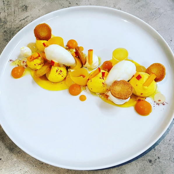Assiette de création culinaire, couleurs dorées et quenelles blanches